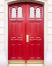 White wall of the house with a closed red wooden door. Royalty Free Stock Photo