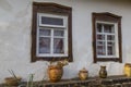 White wall of old clay house with two windows with wooden frame