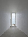 White walls through corridor lead to an open door, from where there is a view of beach and sea Royalty Free Stock Photo