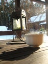 White warm curly cup of hot refreshing coffee stands on a wooden table