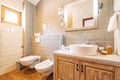 White washbasin with large mirror, towel holder and LED lamp in the bathroom next to the toilet and bidet. Royalty Free Stock Photo