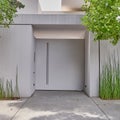 White washed modern house entrance metallic door and bamboo plants