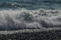 White wave breaking on Sochi Black Sea coast. White spray and foam in the foreground. Emerald blue sea water beyond.