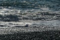 White wave breaking on Sochi Black Sea coast. White spray and foam in the foreground. Emerald blue sea water beyond