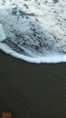 White waves on the sand black beach Royalty Free Stock Photo