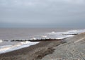 Waves and wooden breakwaters in the sea at thornton cleveleys near blackpool on an overcast cloudy day