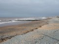 Waves and wooden breakwaters in the sea at thornton cleveleys near blackpool on an overcast cloudy day