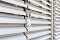 White wavy metal door of an industrial building with locked padllock during quarantine.solar reflections.Outdoor shoot