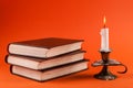 Mystical Illumination: Burning Candle and Vintage Books in Halloween Ambiance