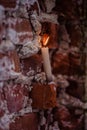 White wax candle burns on a brick background