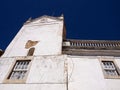 White weathered building tower with clock against blue sky Royalty Free Stock Photo