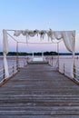 White wedding arch beautifully decorated with flowers on the bridge, pier. Adriatic coast and sea in Slovenia. Holiday, weddings Royalty Free Stock Photo