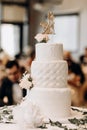 White wedding cake decorated with patterns and a figurine in the form of a bride and groom Royalty Free Stock Photo