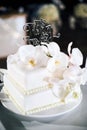 The white wedding cake, 2 layers, decorated with white orchids, with text `it`s party time` Royalty Free Stock Photo