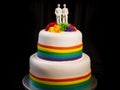 White wedding cake with rainbow colors and gay couple on top. two grooms LGBTQ. Royalty Free Stock Photo