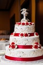 White wedding cake with red fondant icing flowers and red ribbons on each layer Royalty Free Stock Photo