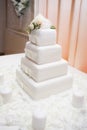 White wedding cake with flowers decorating the top and candles Royalty Free Stock Photo