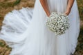 White wedding dress and bride hands holding beautiful bouquet Royalty Free Stock Photo