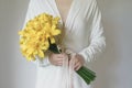 White dress woman holding yellow lily flower bouquet Royalty Free Stock Photo