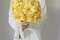 White dress woman holding yellow lily flower bouquet Royalty Free Stock Photo