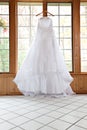 White Wedding Gown Hanging by Window