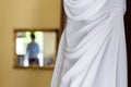 White Wedding Gown with mirror in blurry background.