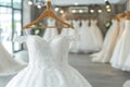 White wedding gowns on hangers in elegant boutique, close up of bridal dresses for sale