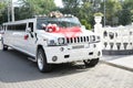 White wedding limousine decorated with red ribbons, wedding rings and flowers. Wedding concept. Royalty Free Stock Photo