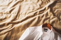 White wedding shirt with a wooden hanger on the bed Royalty Free Stock Photo