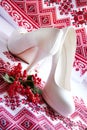 White wedding shoes on a embroidery ukrainian background. Royalty Free Stock Photo