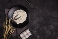 White wheat flour in a wooden spoon on a dark structural background on a plate made of black stone Royalty Free Stock Photo