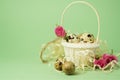 White wicker basket filled with straw,small pink roses,quail eggs on a green background. The concept of Easter Holidays. Easter Royalty Free Stock Photo