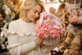 White wicker basket with small pink roses inside in hands of young beautiful blonde woman Royalty Free Stock Photo