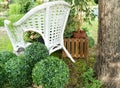 White wicker chair in the garden, plants in pots stand on the chair. Beautiful design Royalty Free Stock Photo