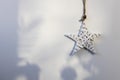 White wicker willow star hangs on the wall. The shadow from the Christmas tree. Place for text. Copy space