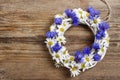 White wicker wreath decorated with cornflowers and chamomiles