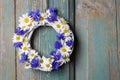 White wicker wreath decorated with cornflowers and chamomiles