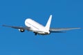 White wide-bodied aircraft takes off into the blue sky.