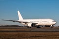 White wide body passenger aircraft taxiing on the main taxiway Royalty Free Stock Photo