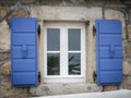 A white window with blue shutters, reflection of plants Royalty Free Stock Photo