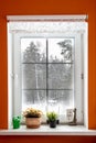 White window in orange room from which the view of the winter forest. Window to snow forest. The windows were frozen and covered Royalty Free Stock Photo