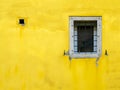 White window on yellow shingled wall. Typical colourful architecture. Space for your text.