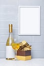 White wine bottle with empty label, glass, gift box and mock-up of frame with copy space for poster Royalty Free Stock Photo