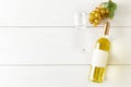 White wine bottle with grapes and wine glass on white wooden table flat lay from above Royalty Free Stock Photo