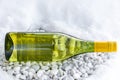 White wine bottle on the gravel in the snow