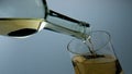 White wine filling goblet closeup. Golden grape beverage bubbling in wineglass.
