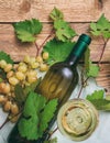 White wine glass and bottle and fresh grapes on wooden background Royalty Free Stock Photo