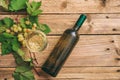 White wine glass and bottle and fresh grapes on wooden background, copy space Royalty Free Stock Photo