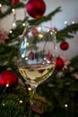 White wine glass tilted to right with Christmas tree in Background, concept of celebration Royalty Free Stock Photo