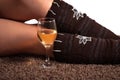 White wine glass and woman legs on carpet floor Royalty Free Stock Photo